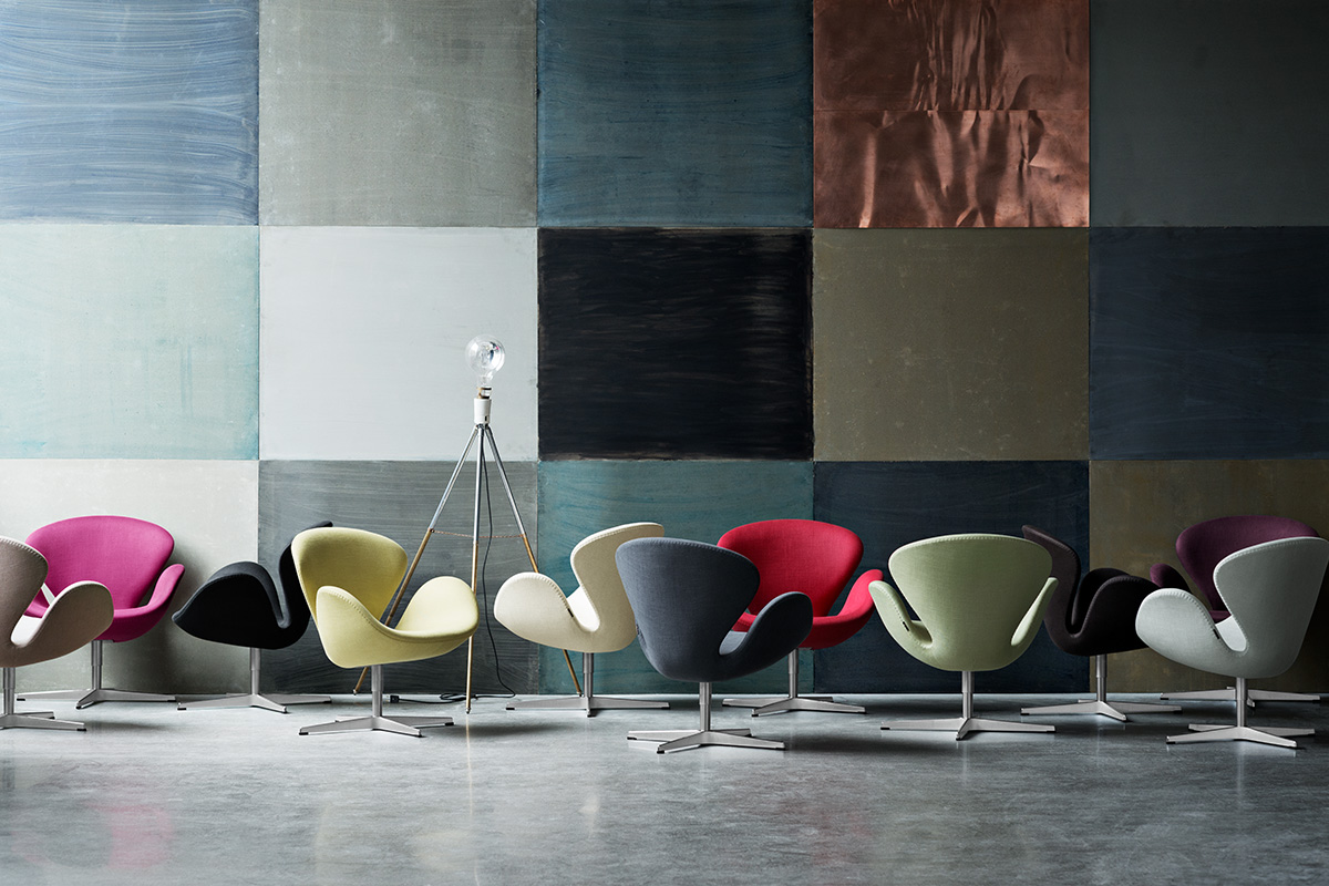 Multicolor armchairs in a concrete room with quilted wall background