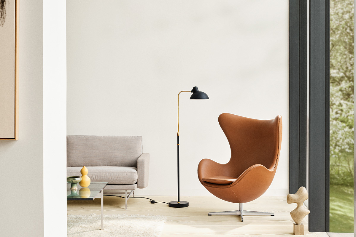 Leather curvaceous chair in a living room setting with black floor lamp